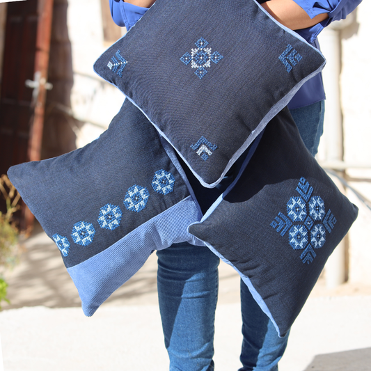 Blue pillow cover with small cross-stitch geometric motif embroidery on the face