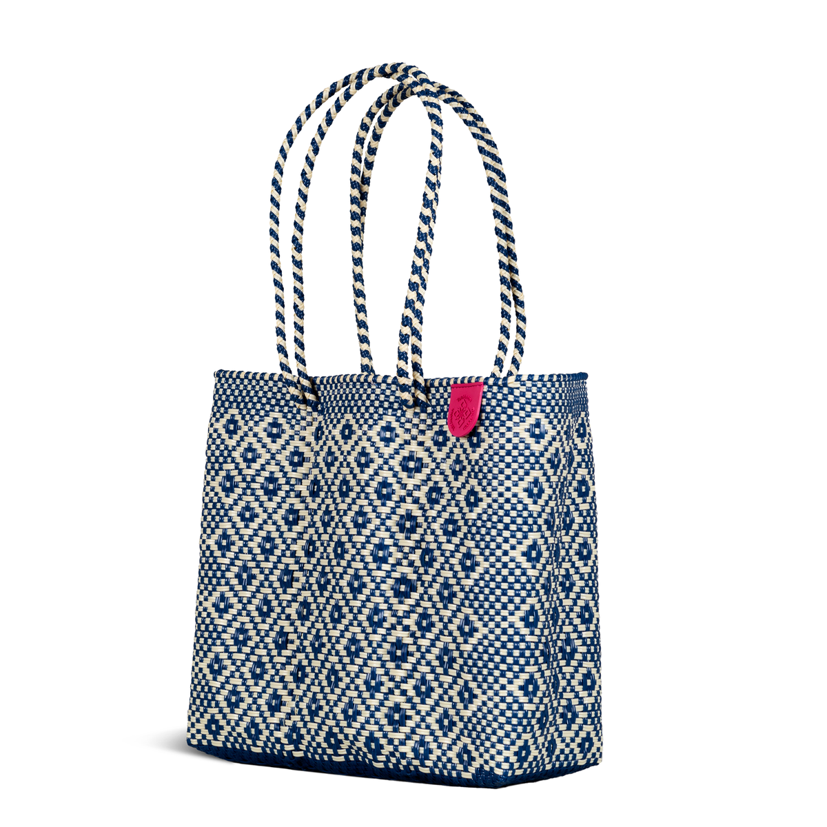 Woven tote bag with blue diamond geometric pattern and pink fabric tag on front