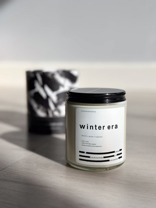Mint-scented candle in clear glass jar with black lid and 'winter era' label