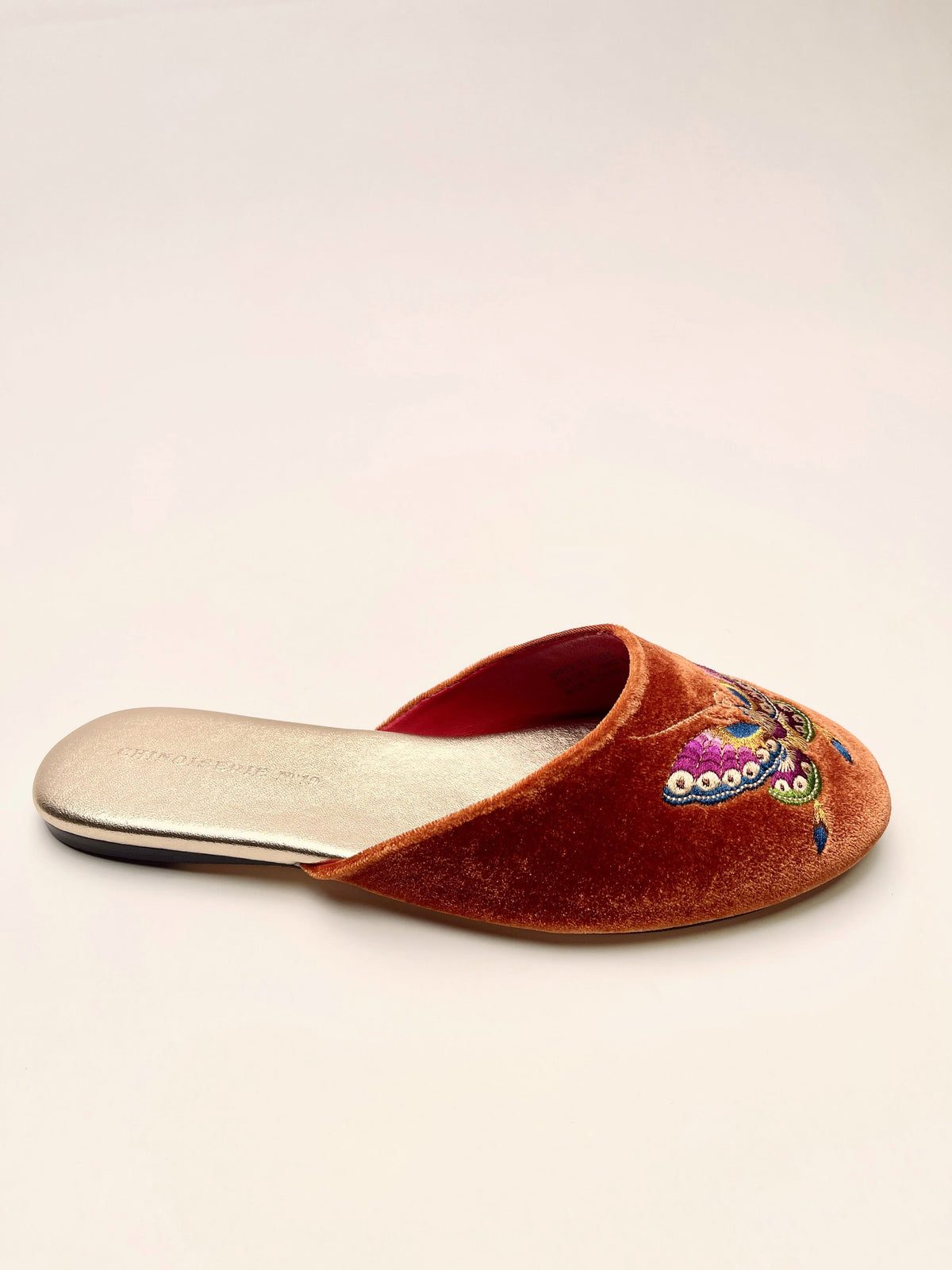 Single burnt orange velvet mule slipper with colorful butterfly embroidery on toe