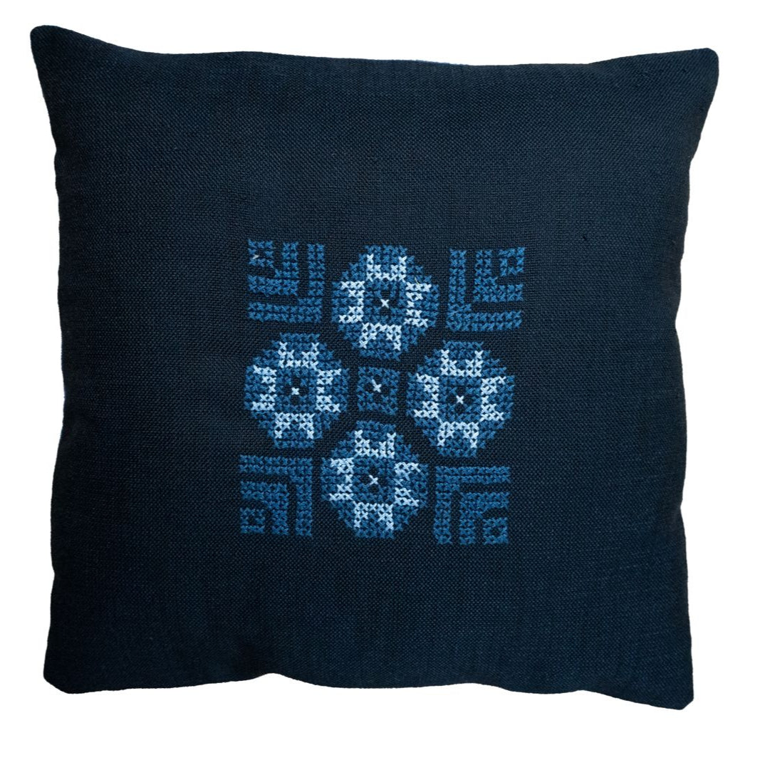 Blue pillow cover with cross-stitch style geometric and snowflake pattern embroidery