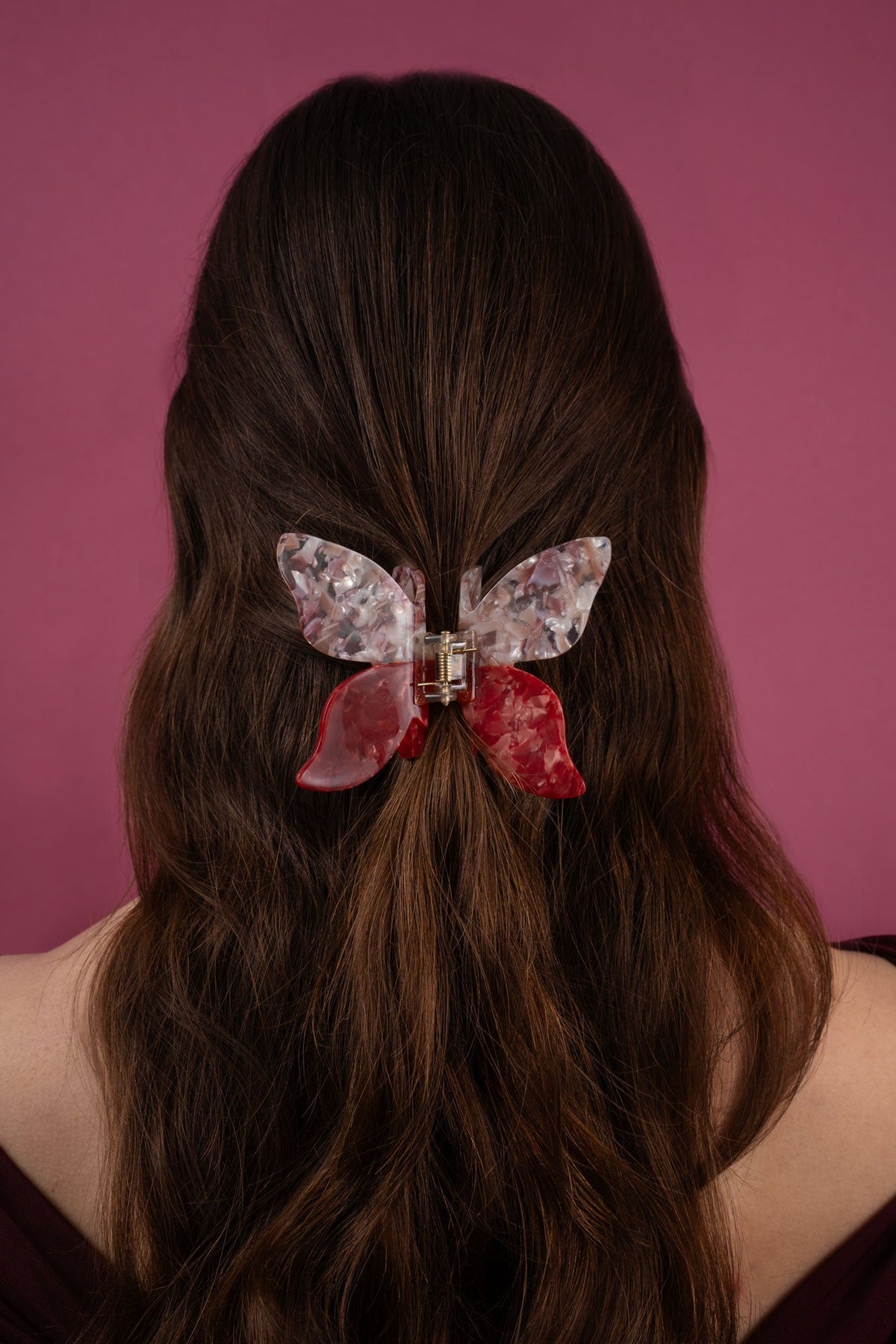 Butterfly hair claw clip on dark hair, marbled pink and ruby red wings