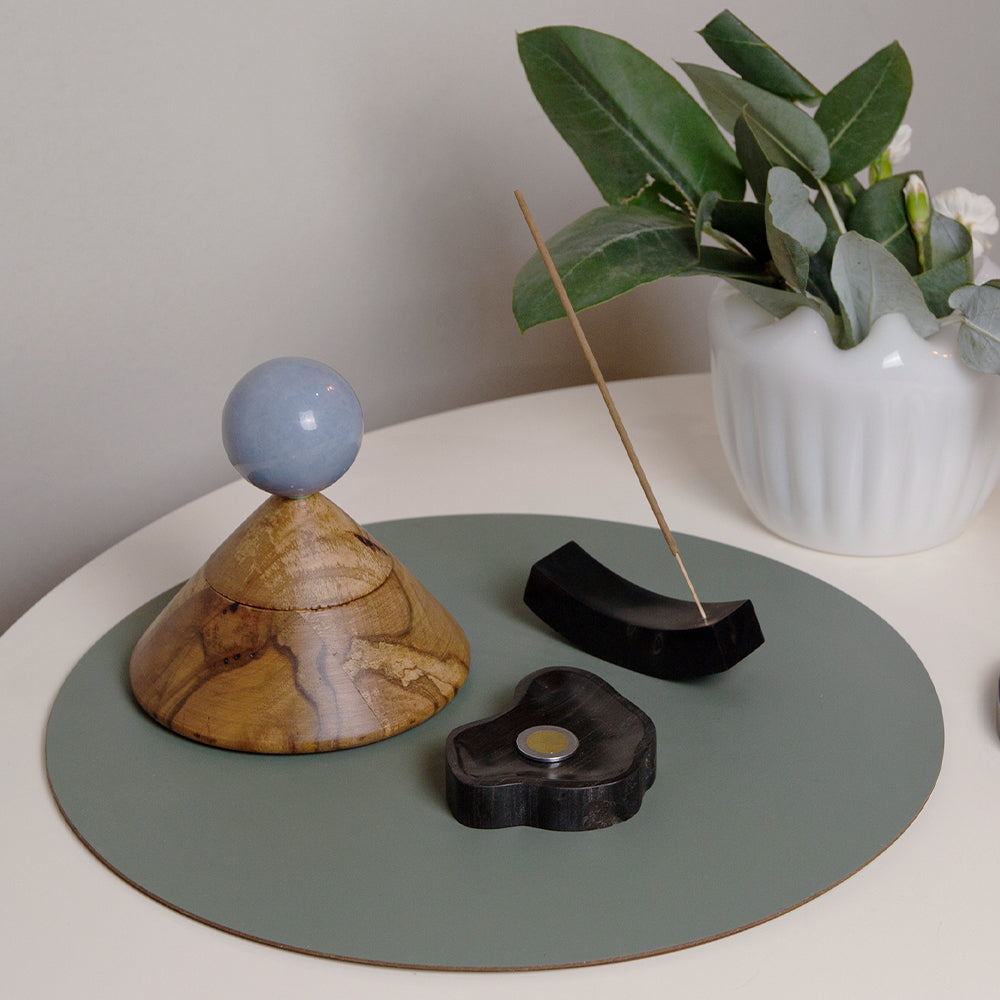 Incense cone holder with blue stone sphere and carved wooden base on round tray