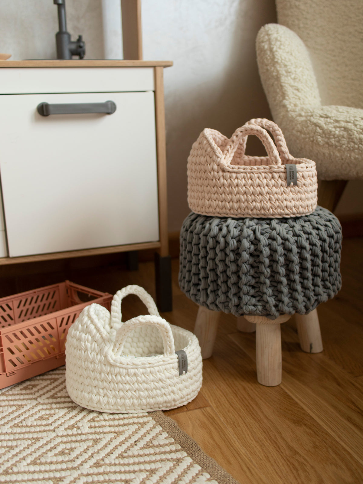 Two woven mini doll baskets with handles on stacked stools