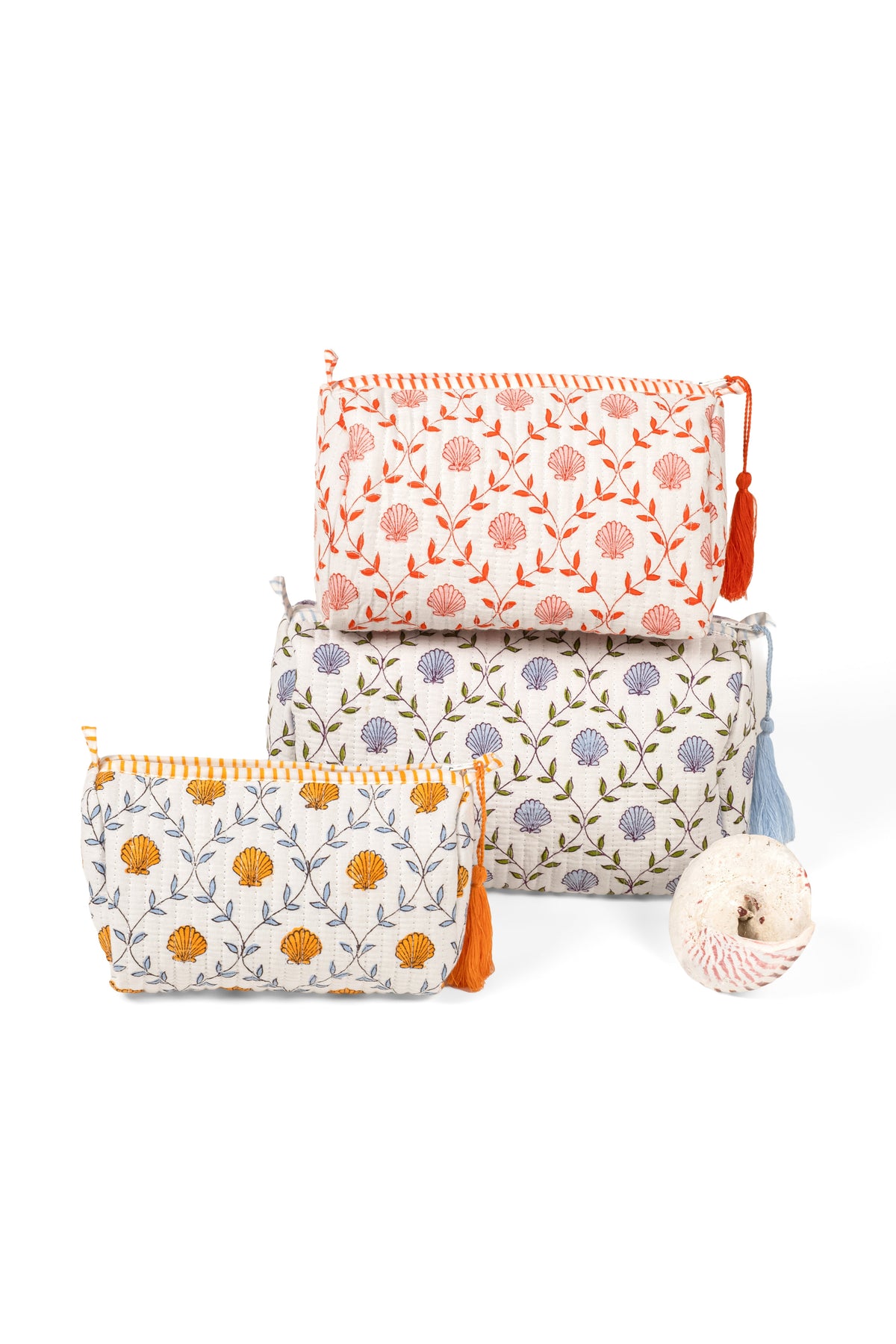 Set of three blockprint makeup bags in white with orange floral circles and tassels