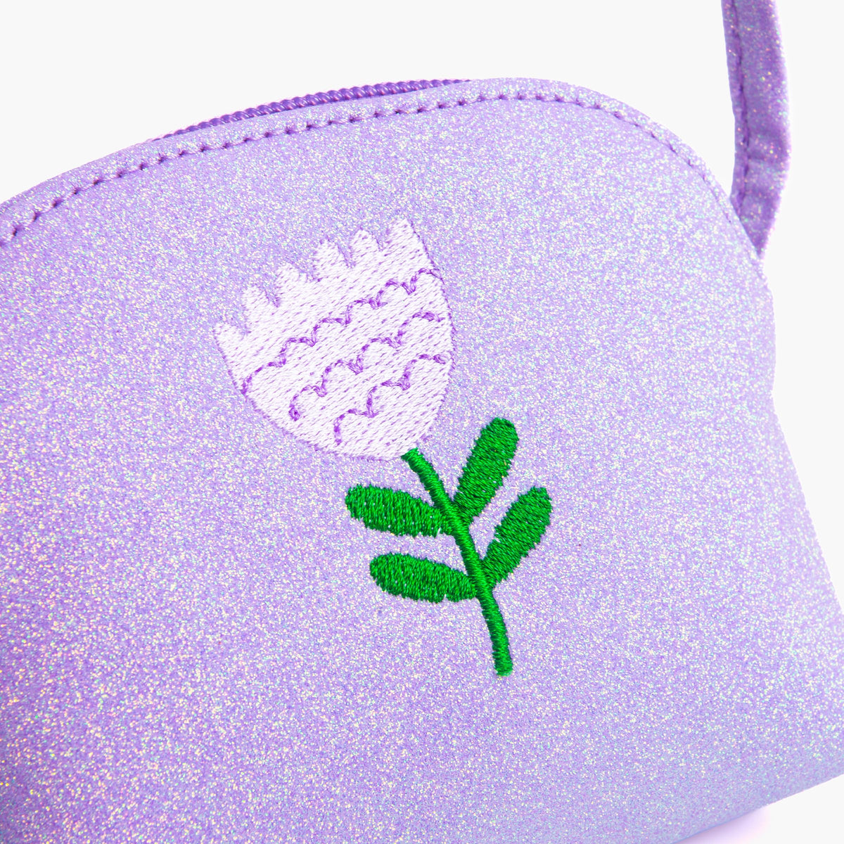 Close-up of purple glitter purse with embroidered flower