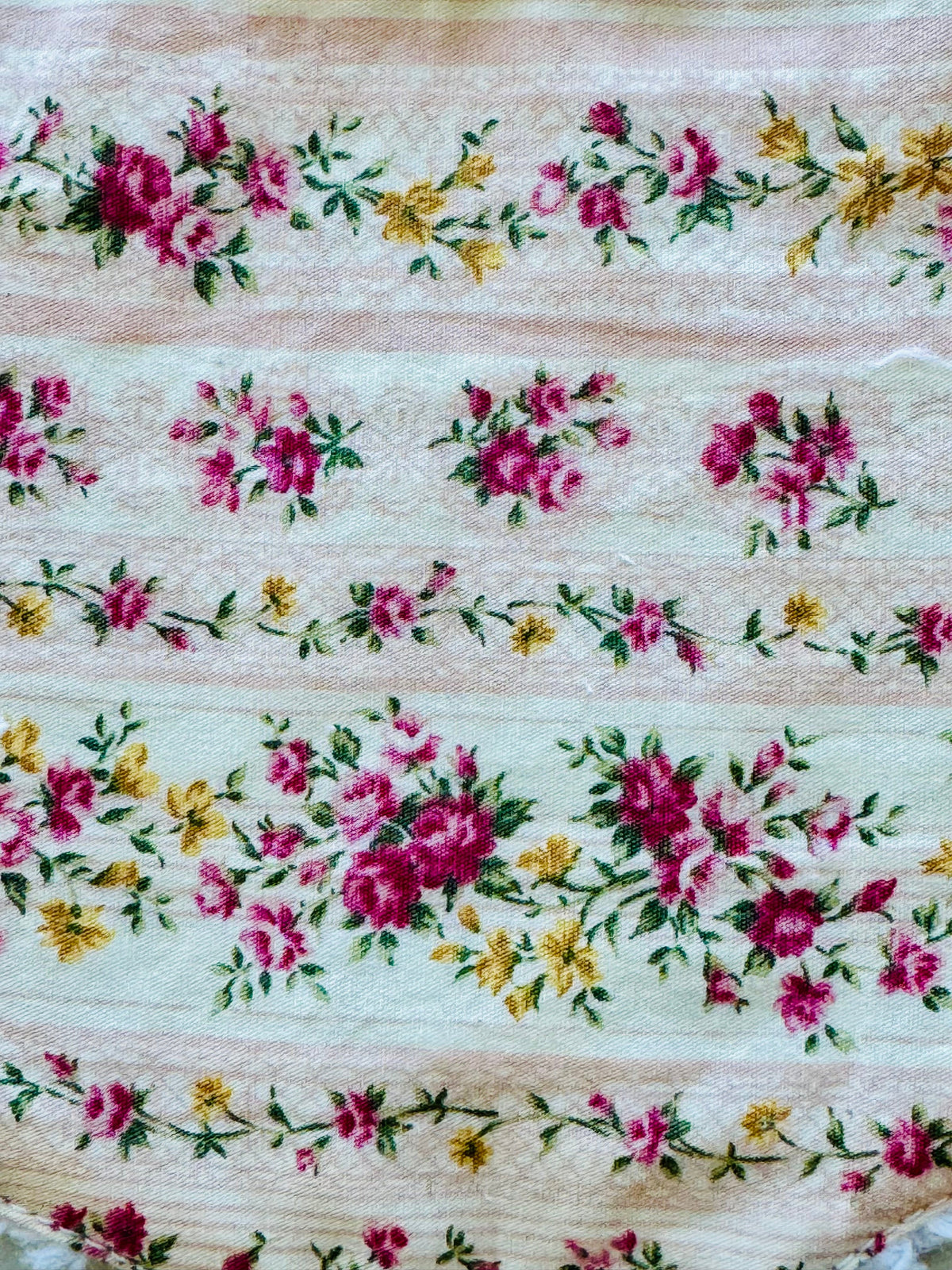 Meadowlark floral fabric close-up: mint ground with pink and yellow flowers