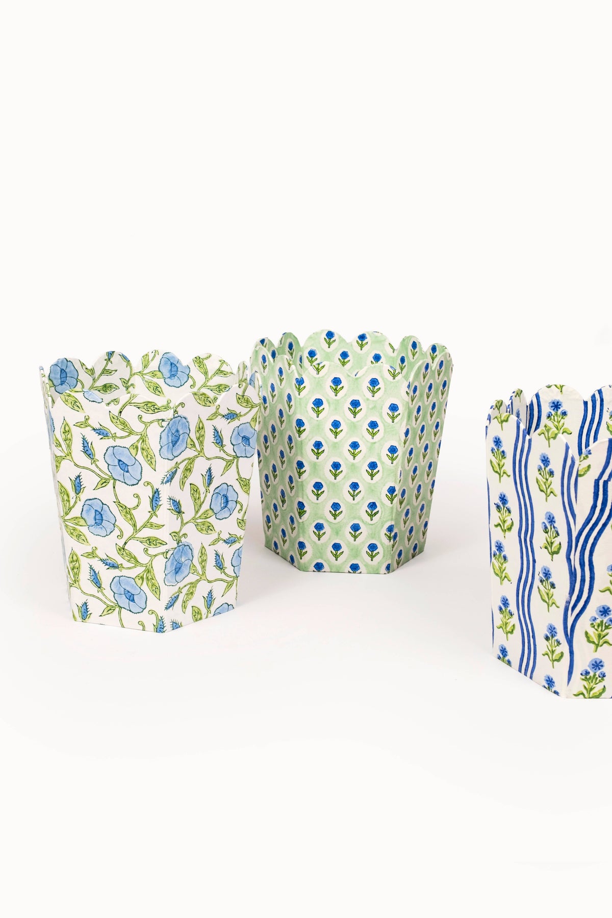 Three collapsible fabric storage baskets with blue and green block print pattern, angled view.
