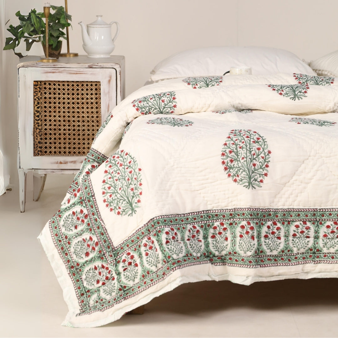 Reversible quilt on bed with white base and green-red border print
