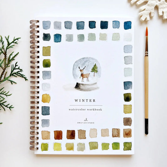 Spiral-bound winter watercolor workbook with snowglobe penguin cover and color swatches