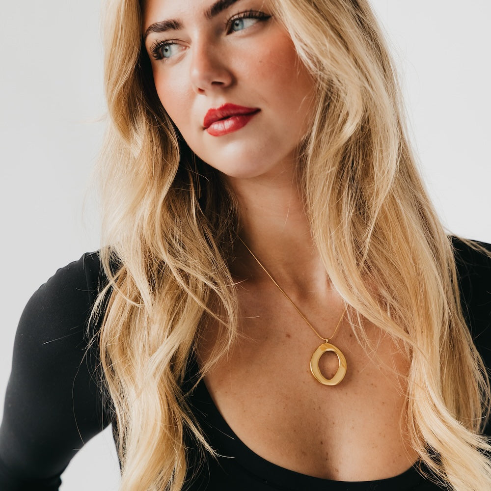 Gold open-circle pendant necklace on model with delicate thin chain
