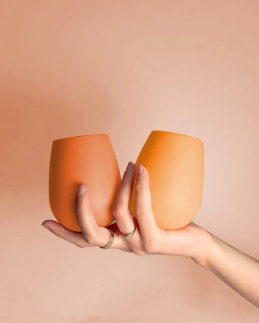 Orange stemless silicone wine glasses, two cups with rounded rim and no stem