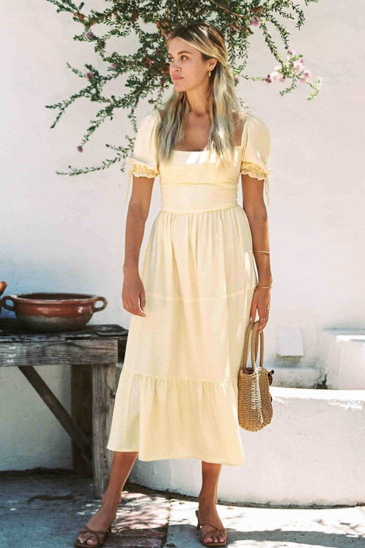 Soft yellow tiered midi dress with short puff sleeves and square neckline