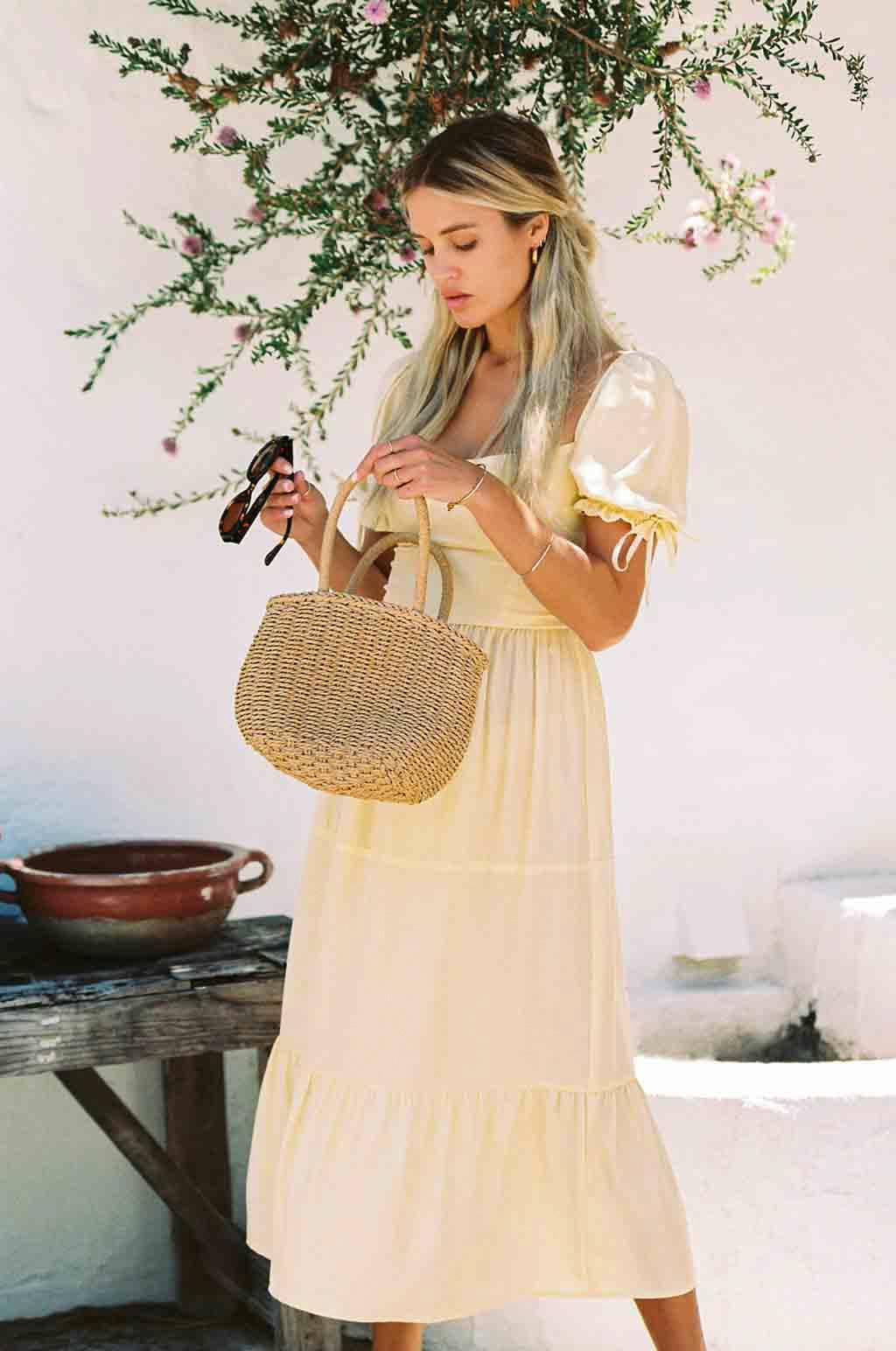 Soft yellow silk midi dress with puff sleeves tied at the cuffs and tiered skirt