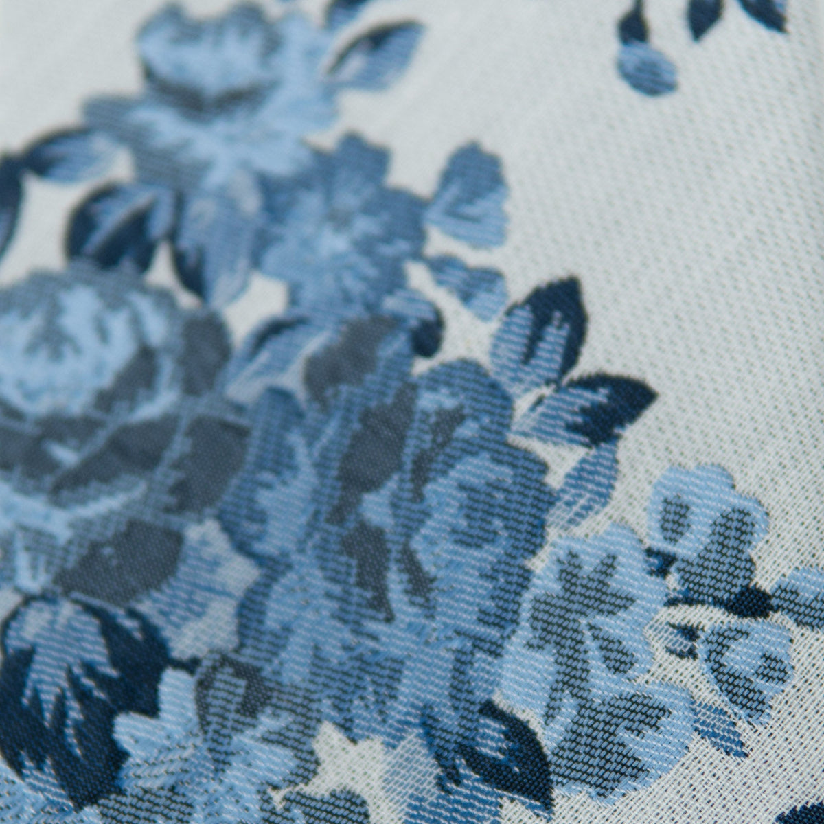 Blue floral bow tie fabric close-up with textured weave and leaf motifs
