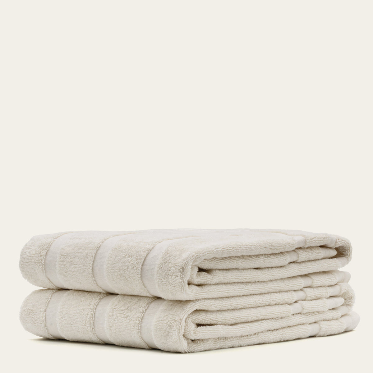 Australian cotton towels, neatly folded off-white towels with textured trim and stripe
