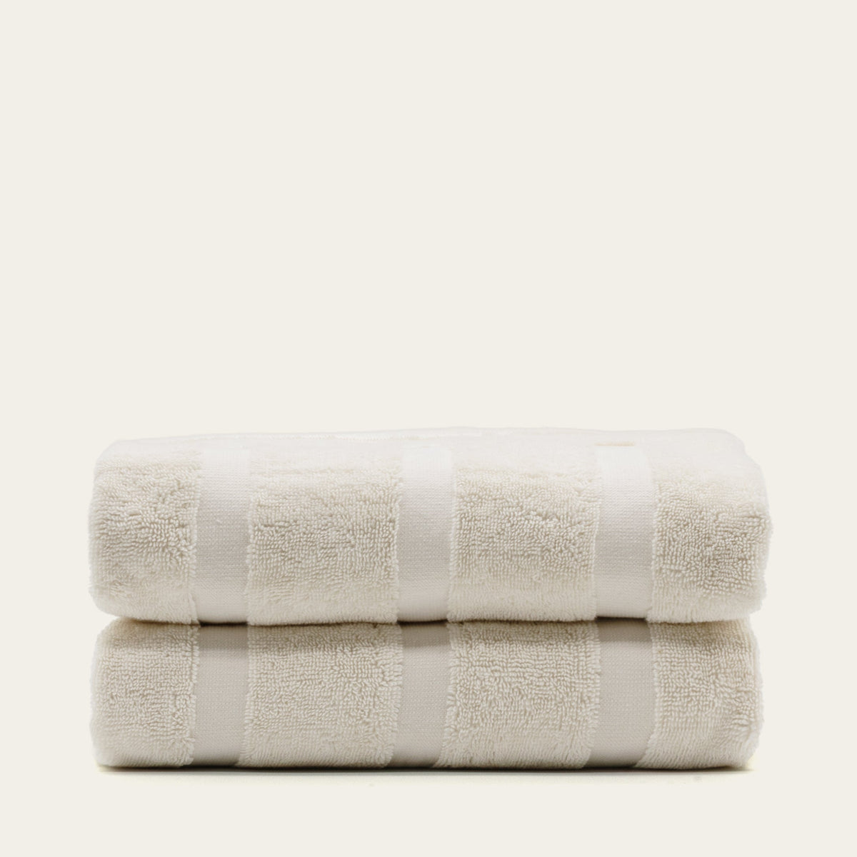 Cream cotton towel pair, layered folds with wide stripe bands