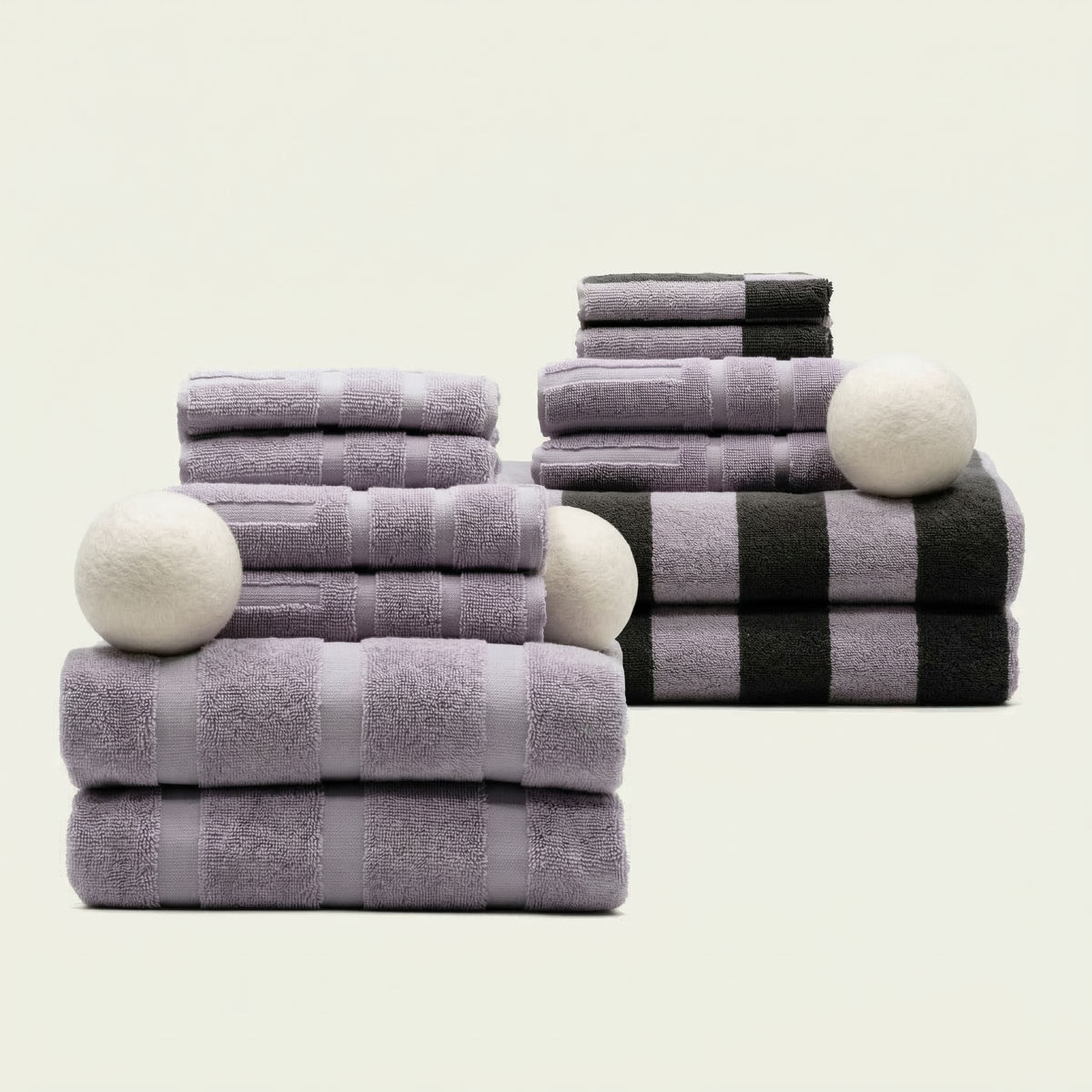 Stacked lilac cotton towels with a black-and-white striped towel layer