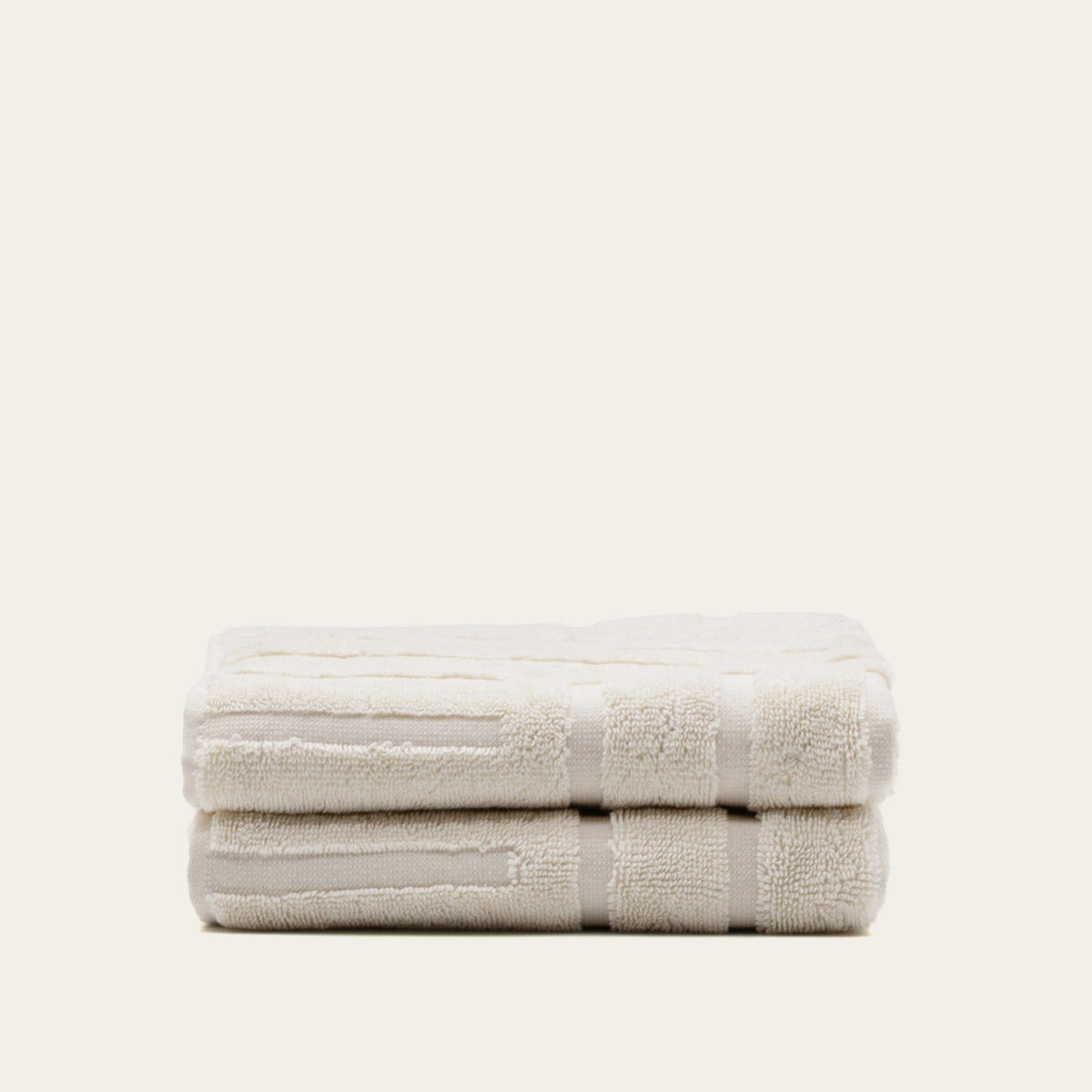 Australian cotton towels, folded light beige towel stack with patterned stripe band