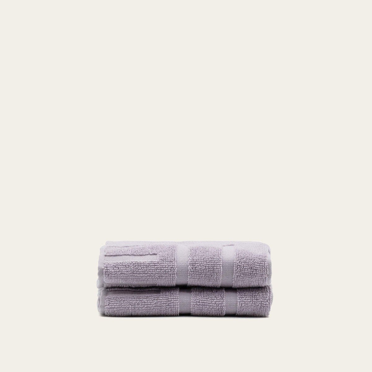 Stack of lilac cotton towels folded into a neat, striped bundle
