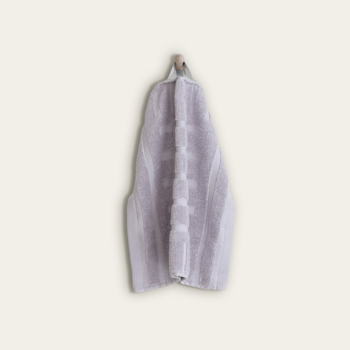 Lilac cotton towel hanging vertically with stitched geometric bands