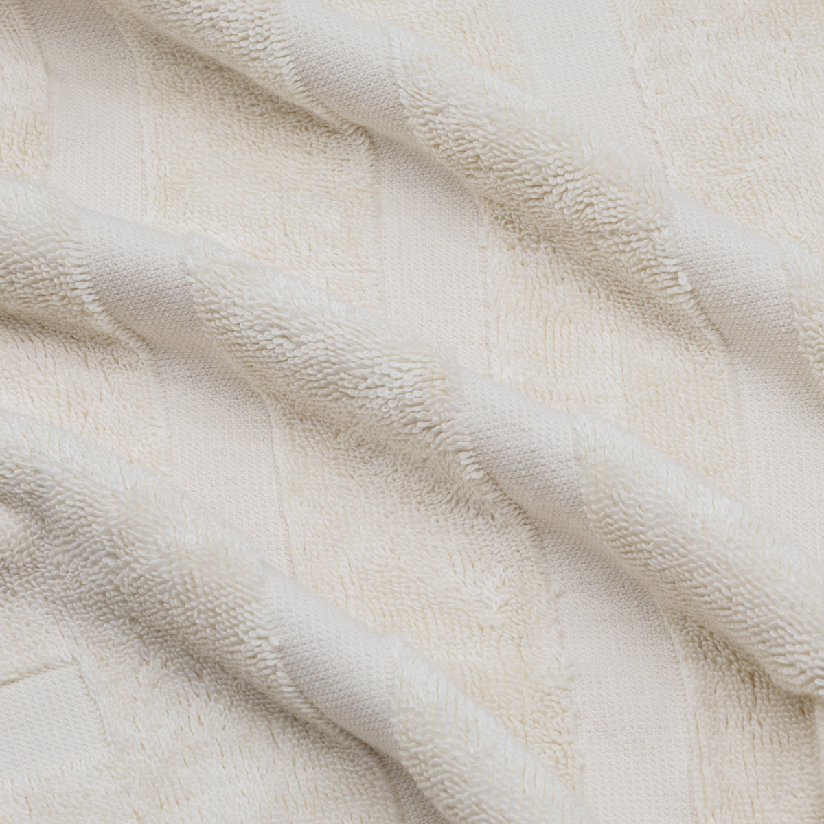 White cotton towel with waffle-like terry texture, close-up fabric detail