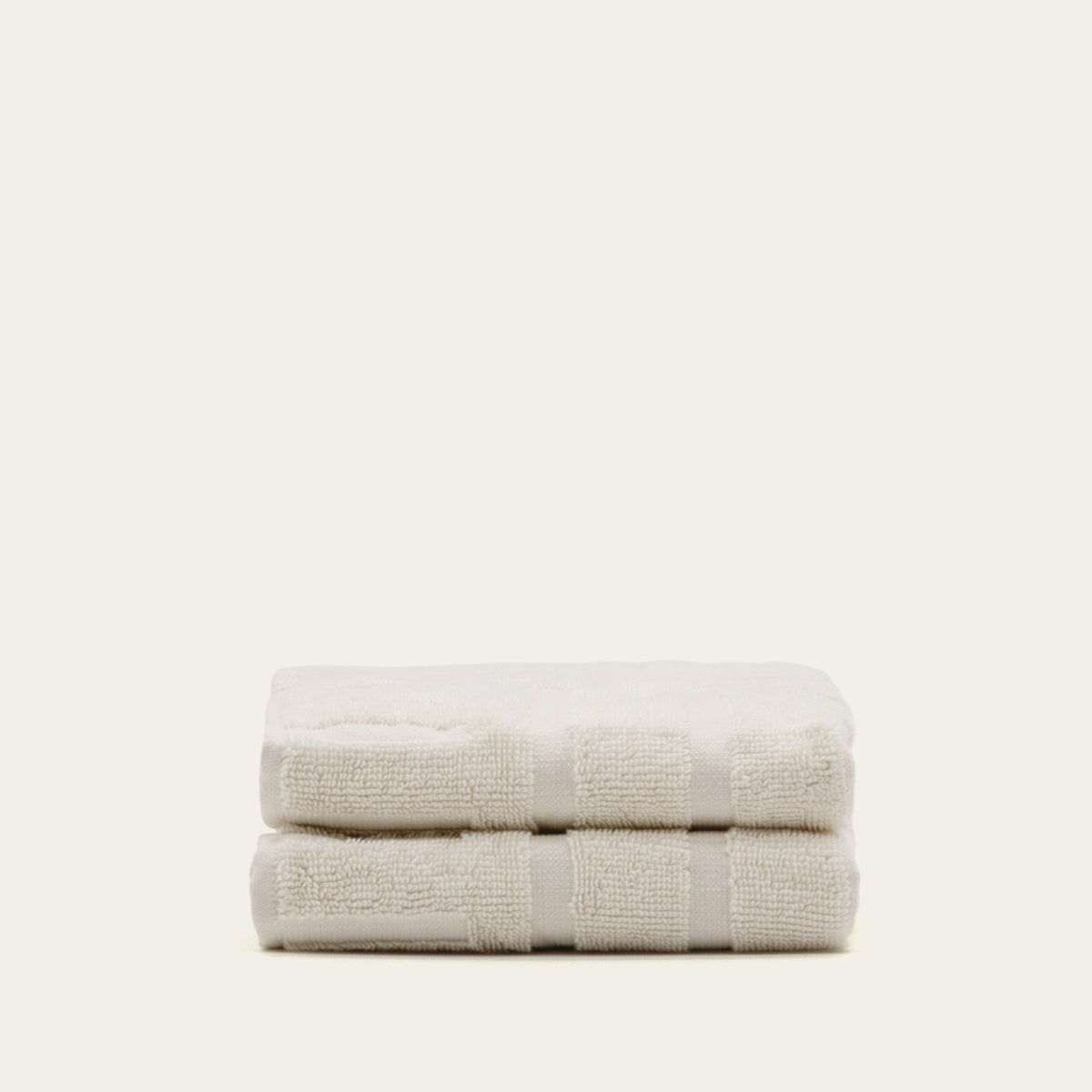 Australian cotton towels, two folded light beige towels with matching striped band