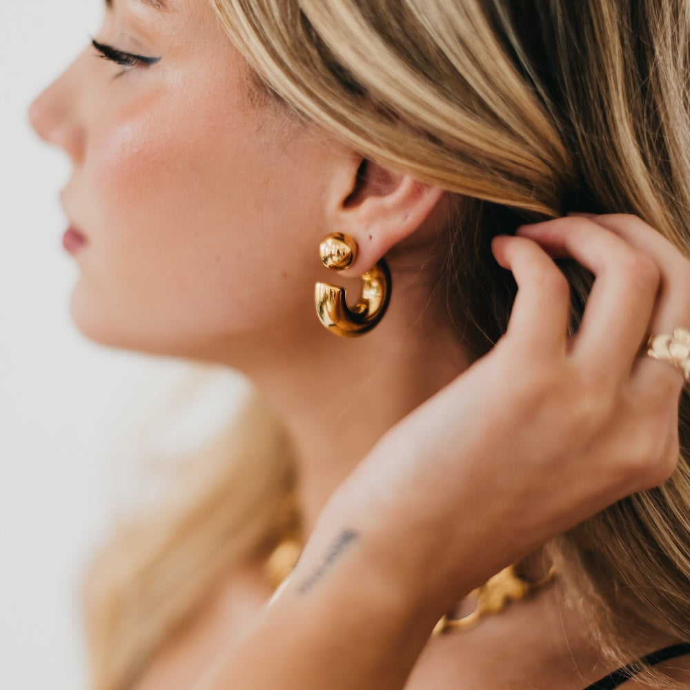 Gold reversible hoop earrings with glossy double-hoop shape and ball stud detail