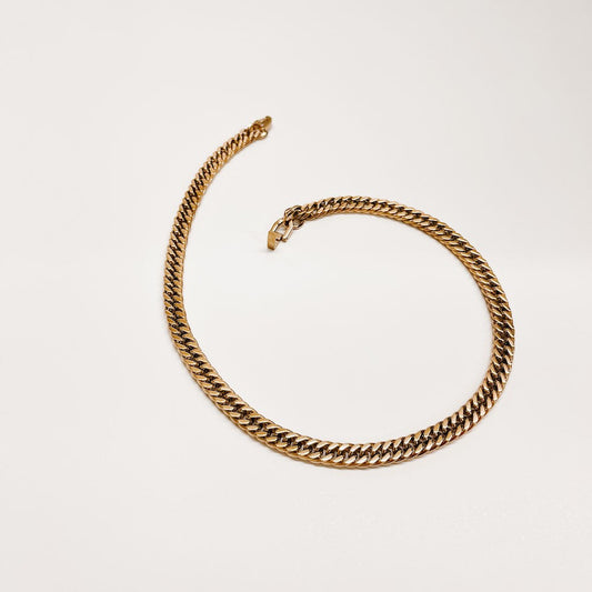 Gold Cuban chain necklace shown flat, coiled chunky links with clasp end