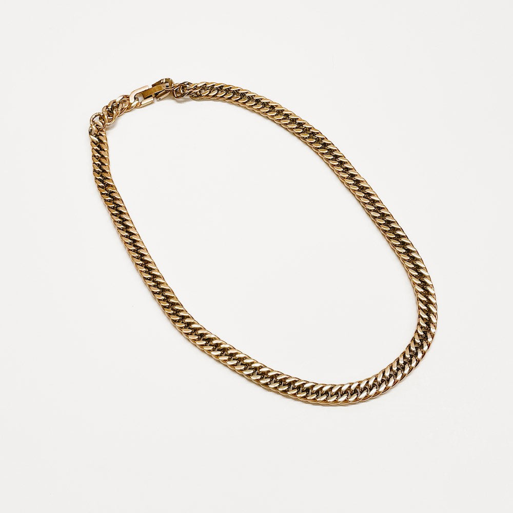Gold Cuban chain necklace flat lay, continuous curb-style chain with clasp at top