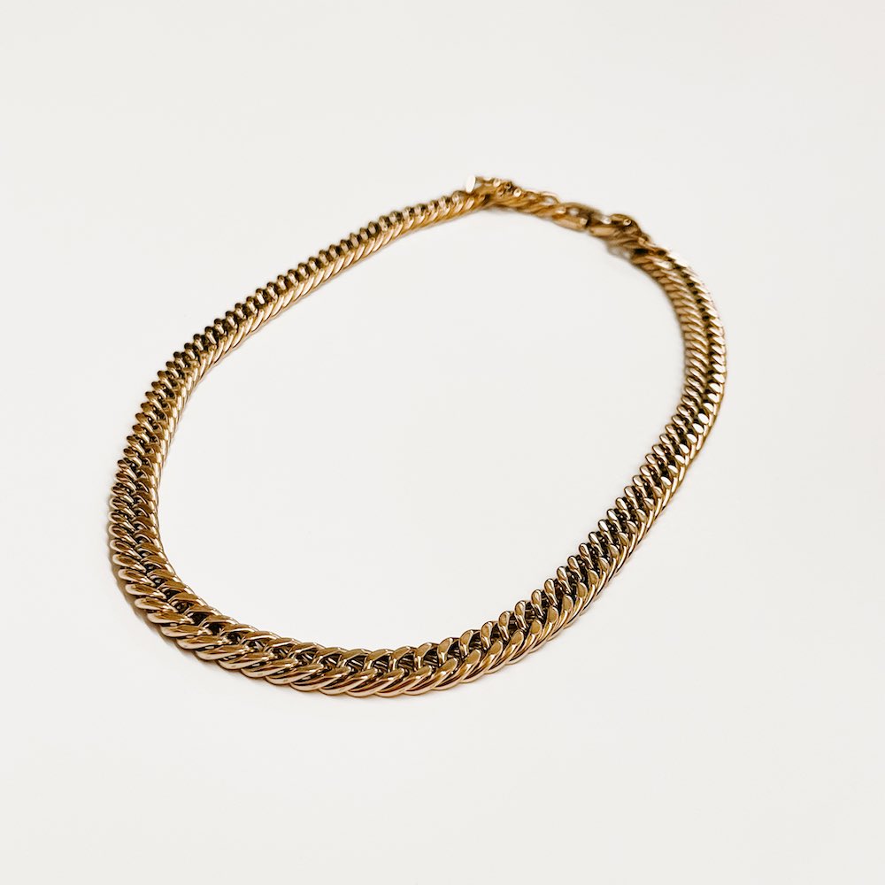 Gold Cuban chain necklace flat lay, evenly linked chunky curb chain
