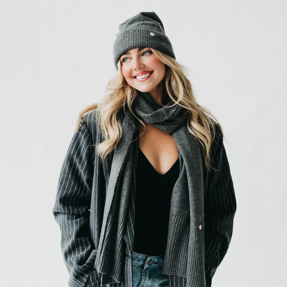 Charcoal cashmere wrap scarf and knit beanie set, draped over shoulders