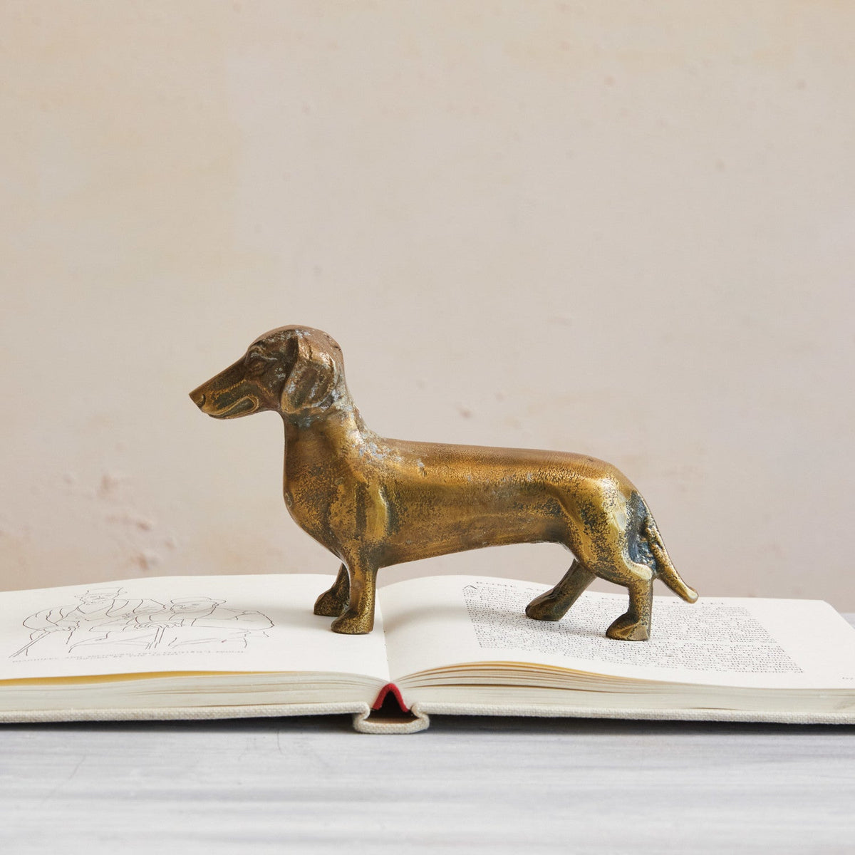 Antique brass dachshund figurine in cast aluminum, front-facing stance.