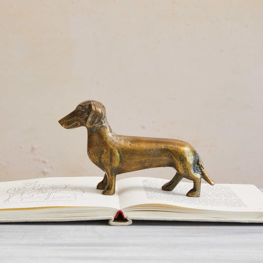 Antique brass dachshund figurine in cast aluminum, front-facing stance.