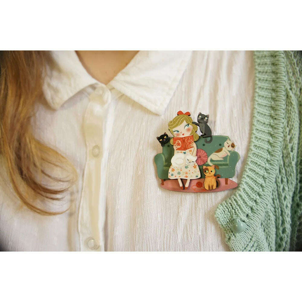 Cat lover brooch on white shirt, girl reading with cats in orange book scene