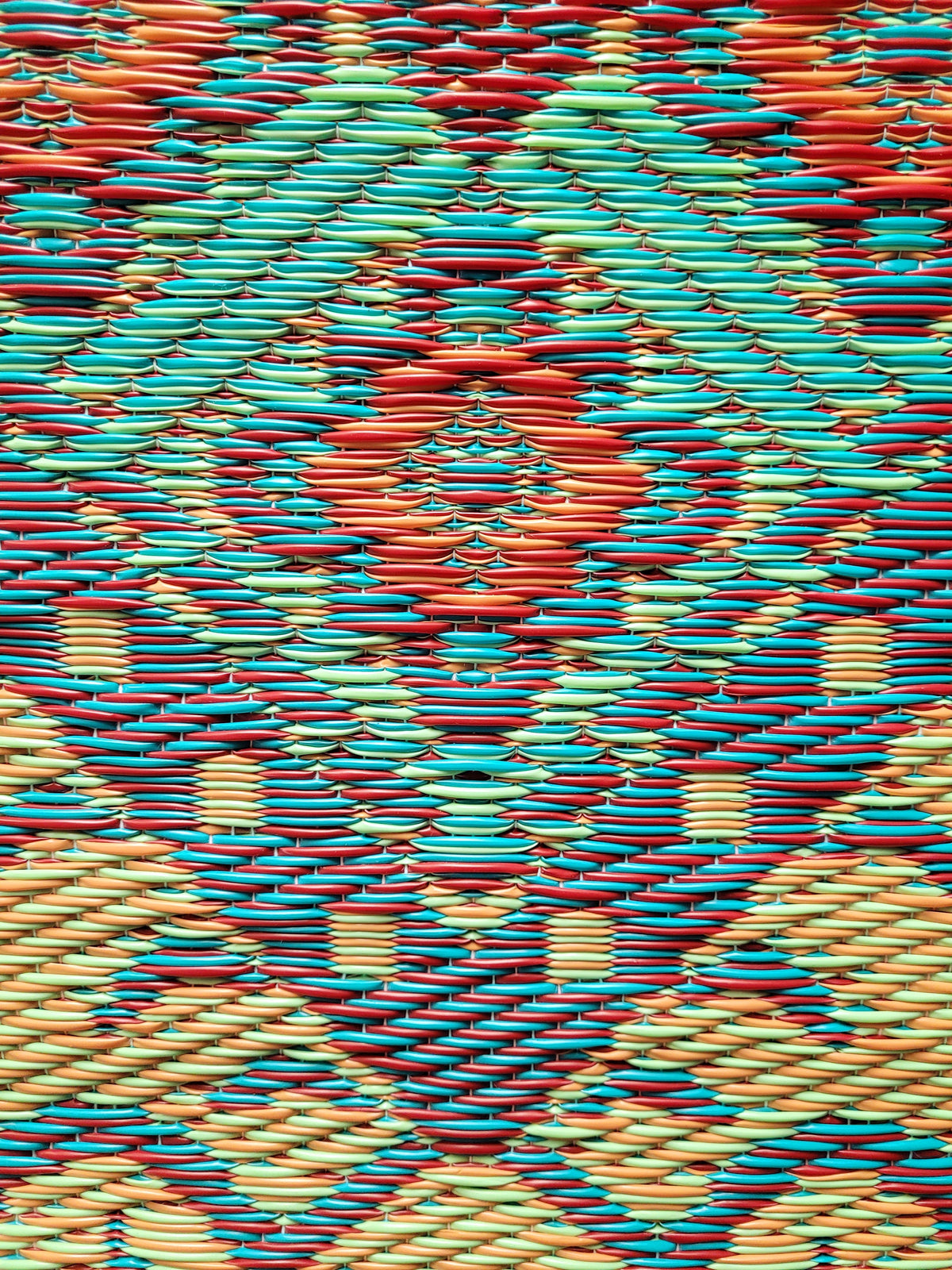 Close-up of Turkish-style rug with blue, orange, teal, and yellow geometric shapes