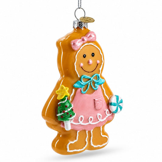 Glass gingerbread girl ornament, side view, with pink dress, teal bow, and candy-cane accents