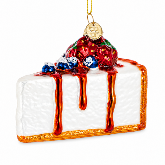 Glass cheesecake Christmas ornament with red berry topping, blue crumb, and orange dripping glaze