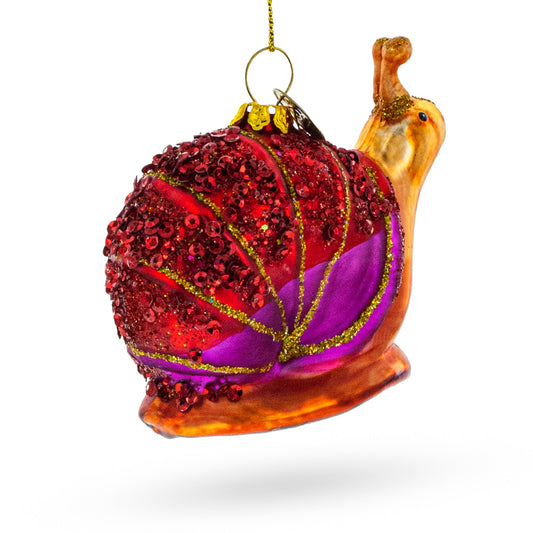 Snail glass ornament with red glitter body, purple accents, and gold details
