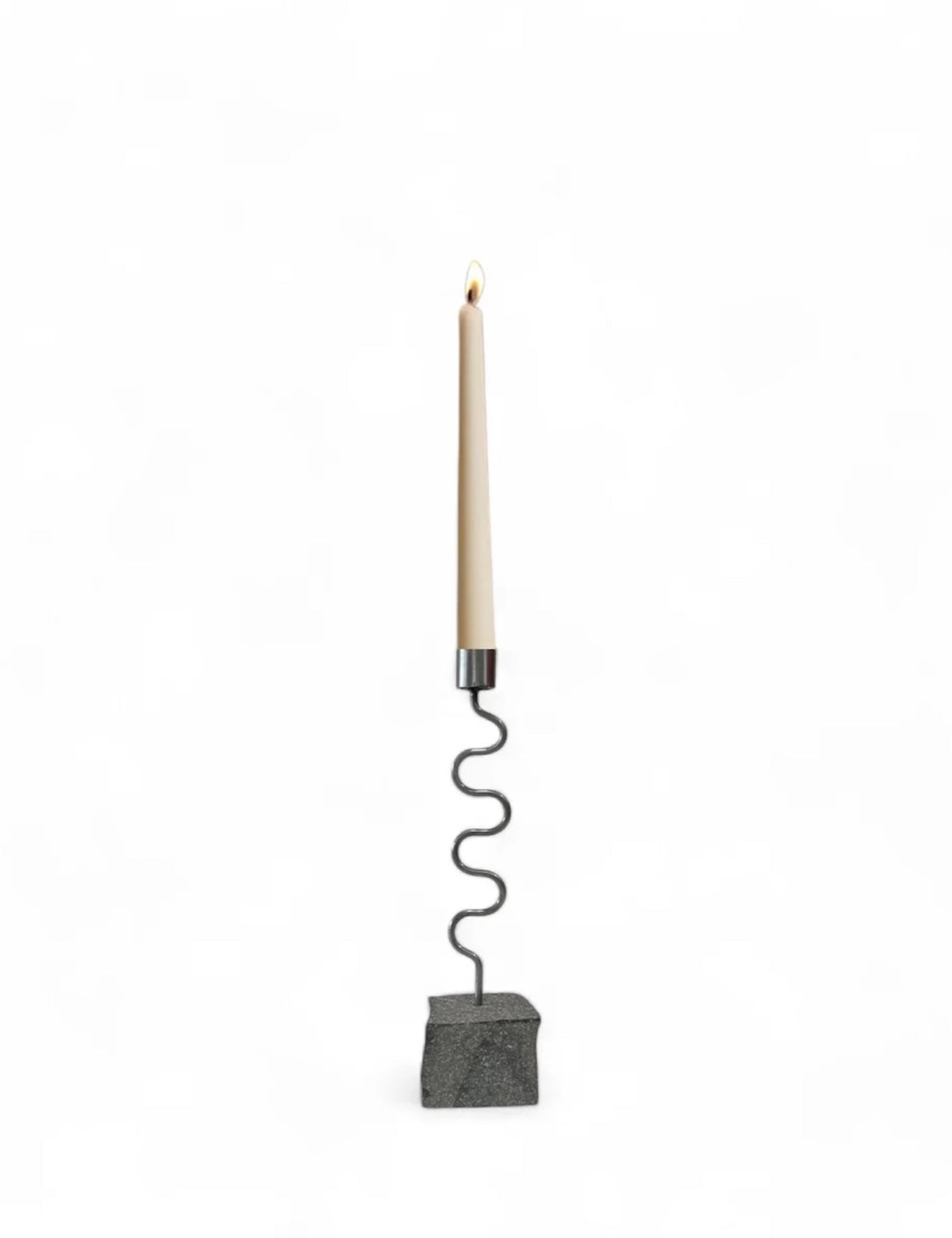Candle holder with tall white candle, wavy metal stem, and dark gray block base