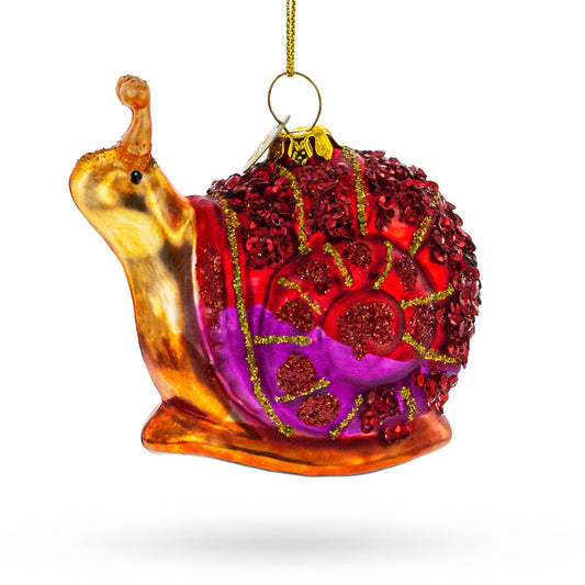 Snail-shaped glass Christmas ornament with red sequins and purple swirls