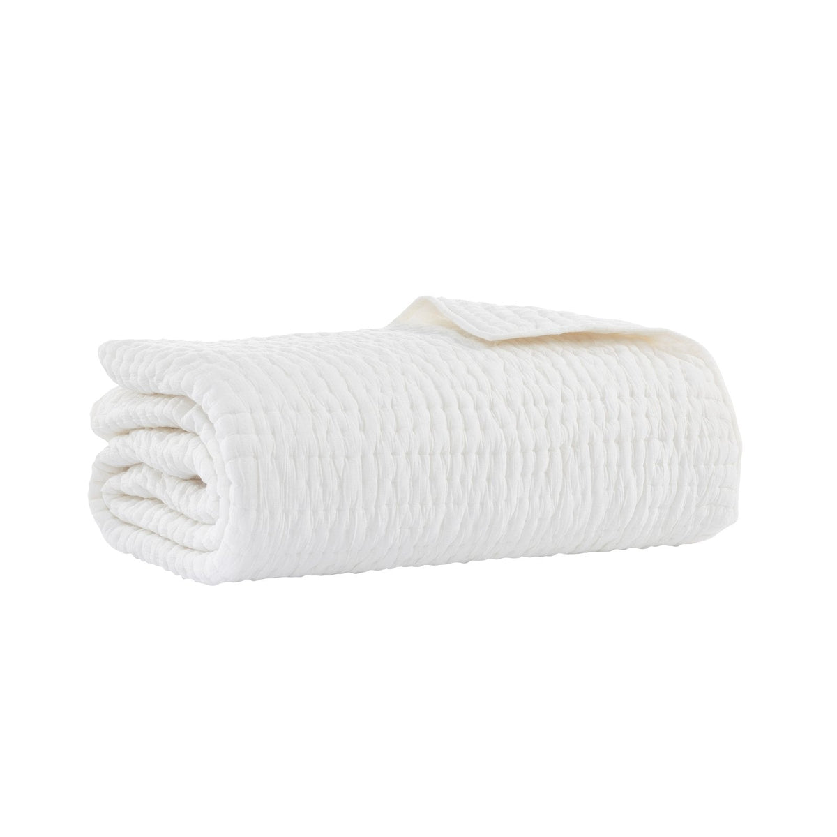 White washed-cotton quilt folded with a visible stitched edge and texture