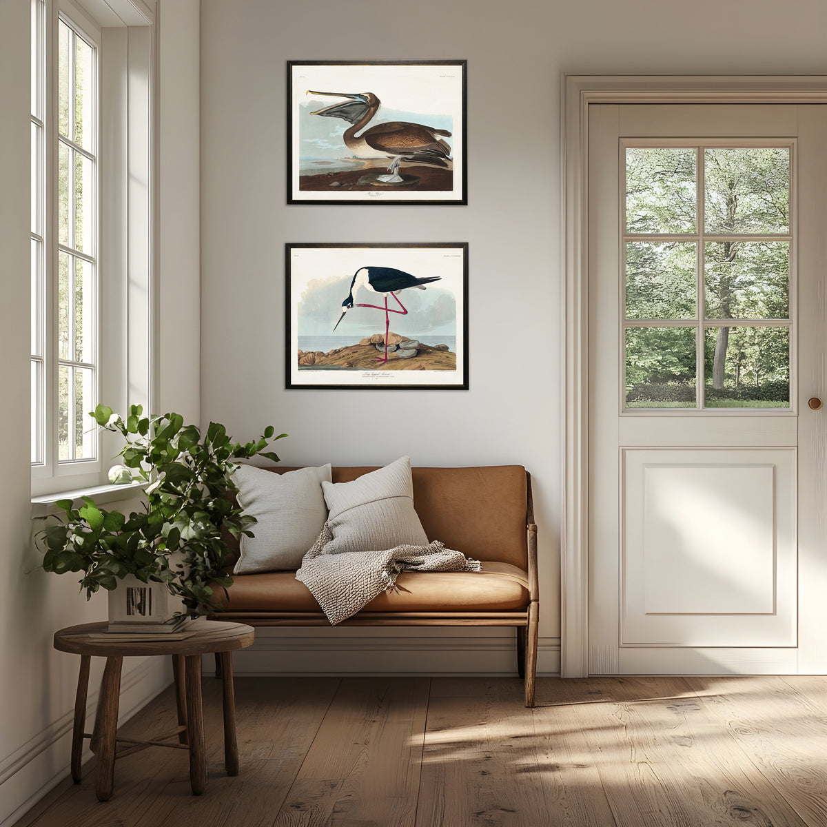 Two small framed pelican prints with black frames and copper trim