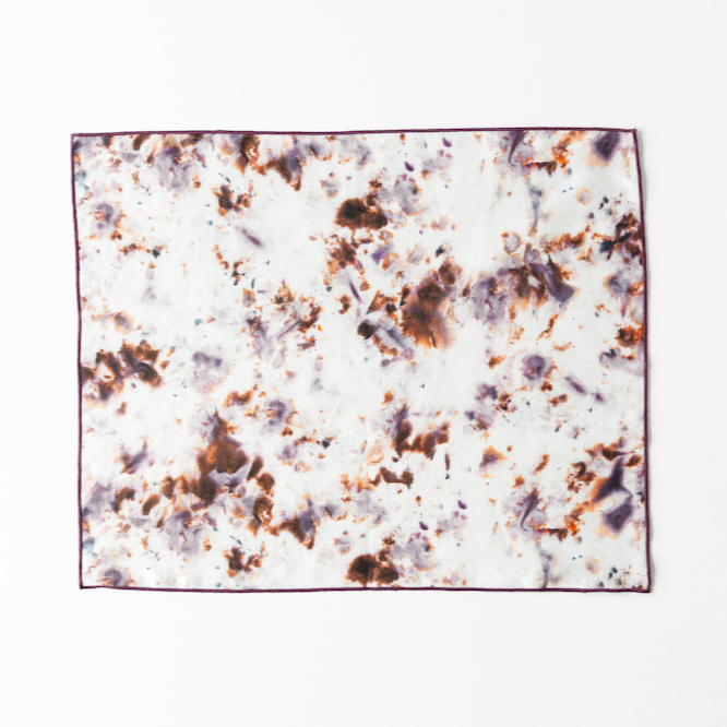 Marble rose placemat with plum trim; white mottled with rose-brown and blue-gray speckles