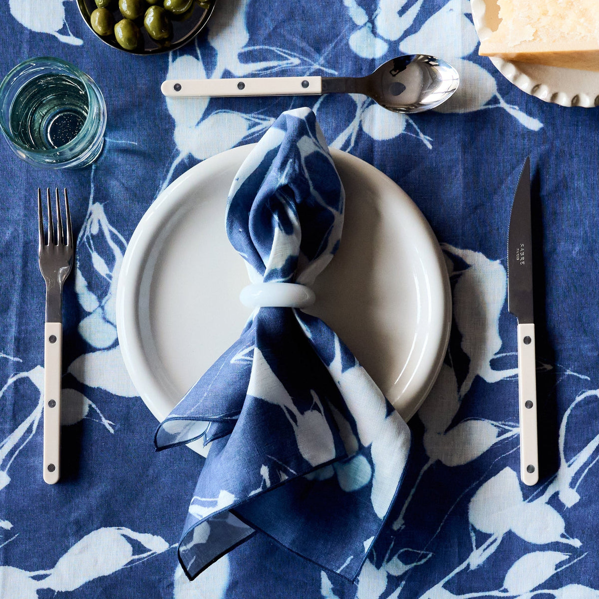 Indigo napkin with white botanical Porto print, tied for table setting