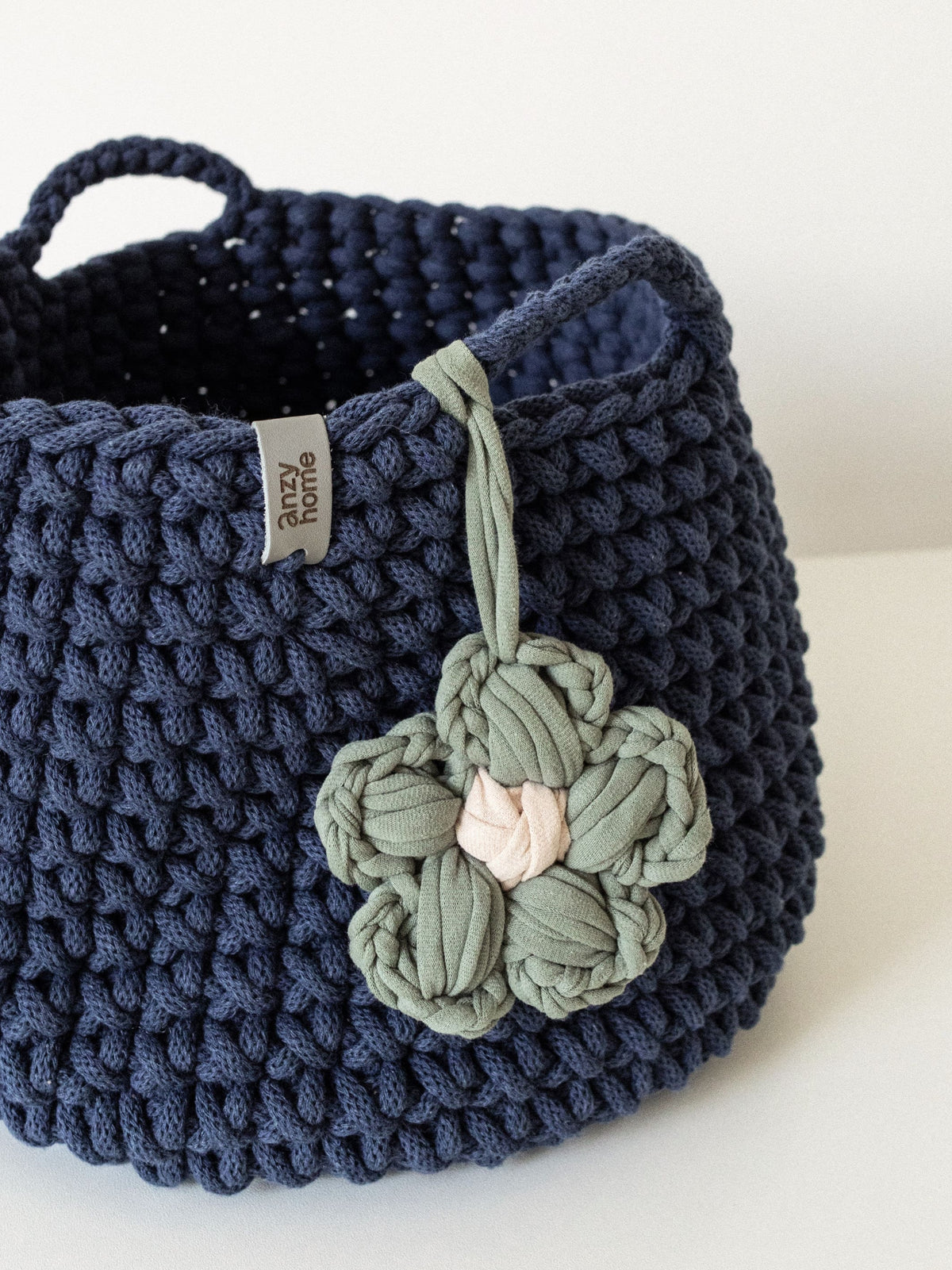 Toy nursery storage basket in dark blue knit with handles and flower charm