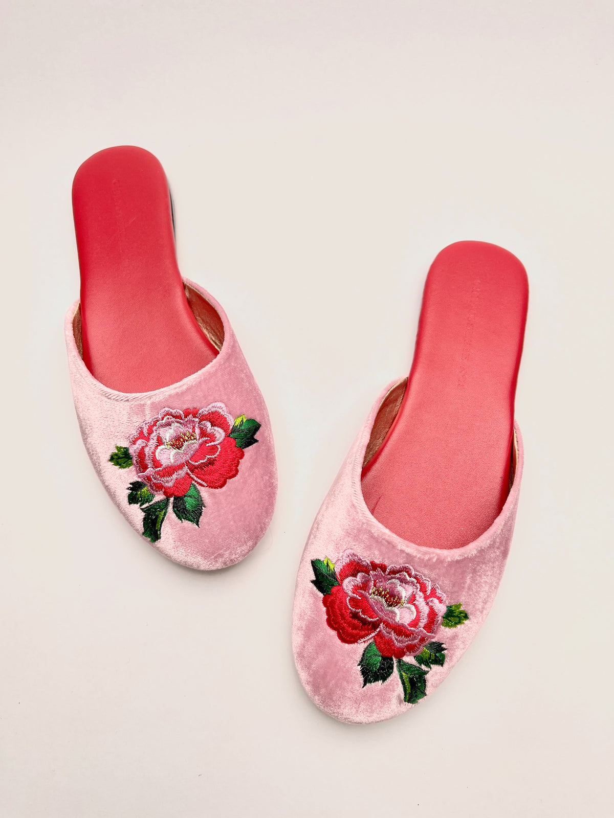 Pair of lavender pink velvet mules with peony flower embroidery and red outsole