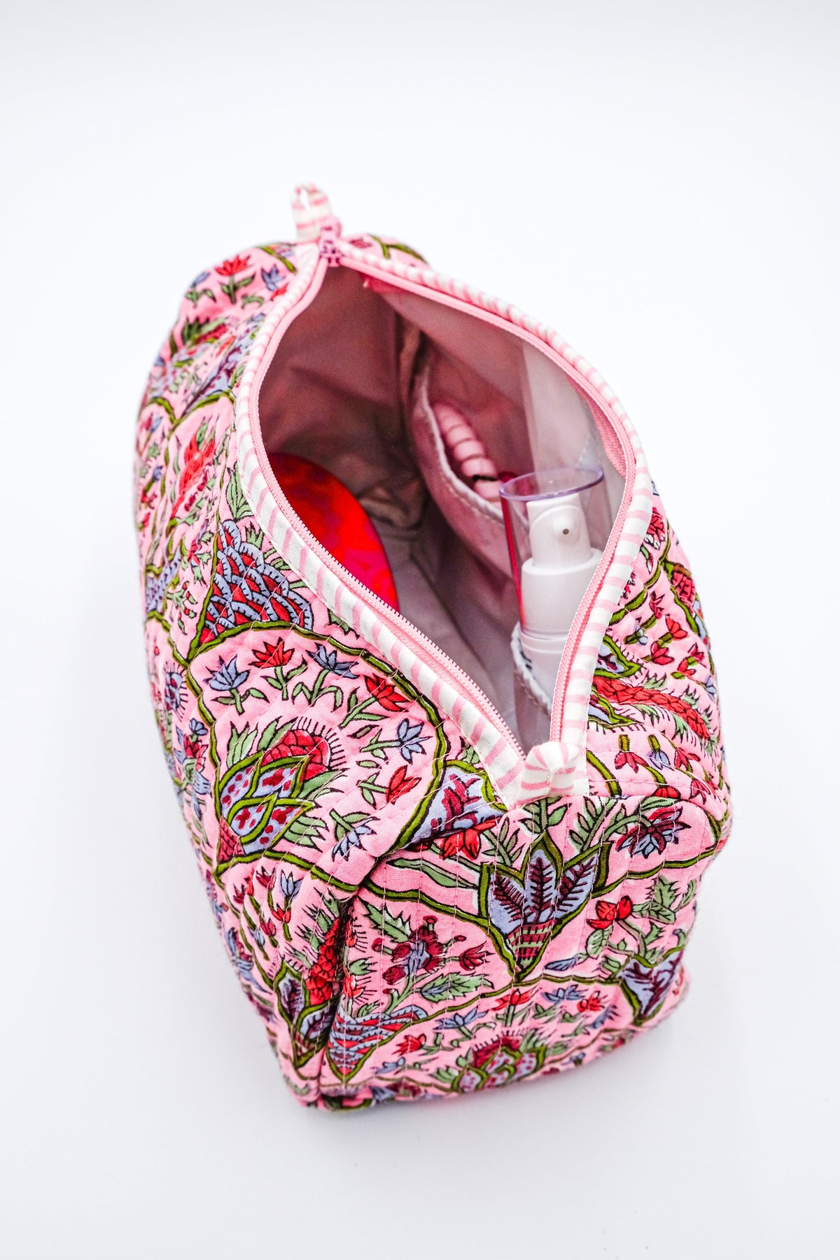 Toiletry bag open top interior with patterned lining and a see-through pocket