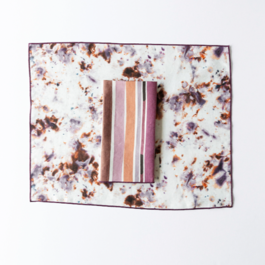 Marble rose placemat with plum trim; white speckled design with lavender striped insert