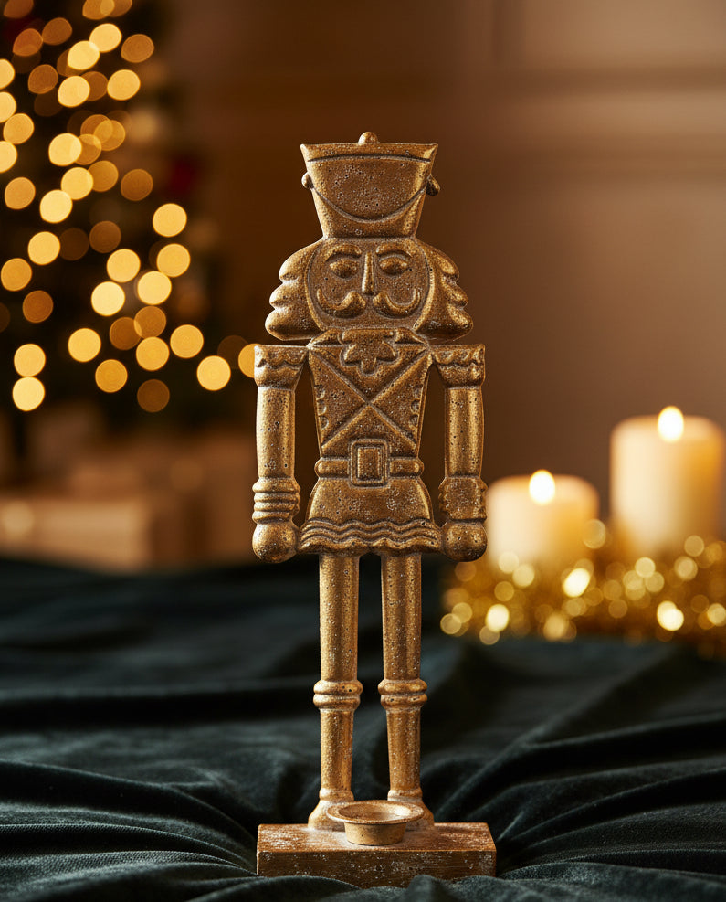 20.5-inch metal nutcracker candle holder with a bronze finish and a candle cup at its feet